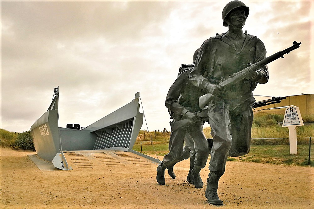On which D-Day landing beach can you find a memorial depicting American soldiers disembarking from an LCVP (